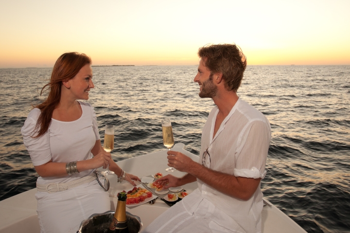 Couple on sunset cruise drinking champagne